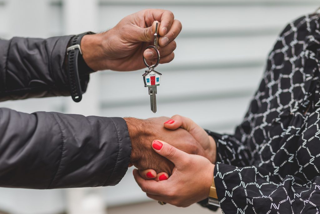 Real estate agent handing over key to client